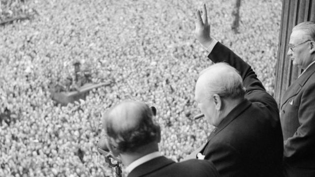 Winston Churchill desde un balcón, saluda a una multitud