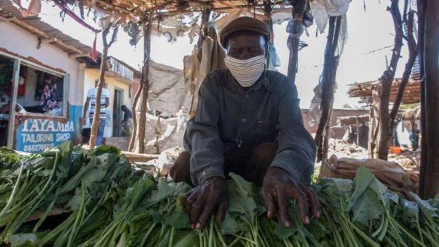 Malavi'de pazarda sebze satan bir adam