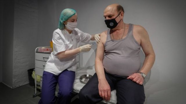 Enfermeira aplica vacina em homem russo