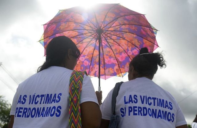 Dos partidarias del acuerdo de paz con las FARC que llevan camisetas que dicen "Las víctimas sí perdonamos".