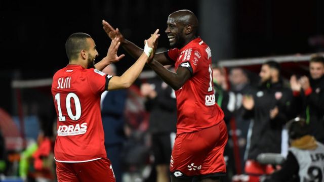 L'attaquant cap-verdien de Dijon Julio Tavares (D) célèbre un but avec le milieu de terrain tunisien Naim Sliti (G) lors du match de football L1 entre Dijon (DFCO) et Angers (ASCO) le 19 mai 2018, au stade Gaston Gerard à Dijon, dans le centre-est de la France.