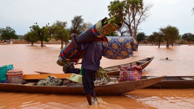Un sinistré embarque ses effets dans une pirogue dans un quartier inondé de Niamey, le 5 septembre 2016.