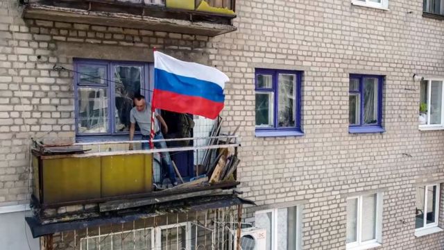 Région de Louhansk, un drapeau russe est accroché à un balcon à Lysychansk