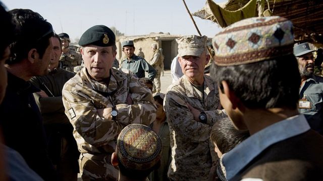 El general británico Nick Carter (con la boina) y el brigadier general estadounidense Larry Nicholson conversan con afganos, noviembre de 2009