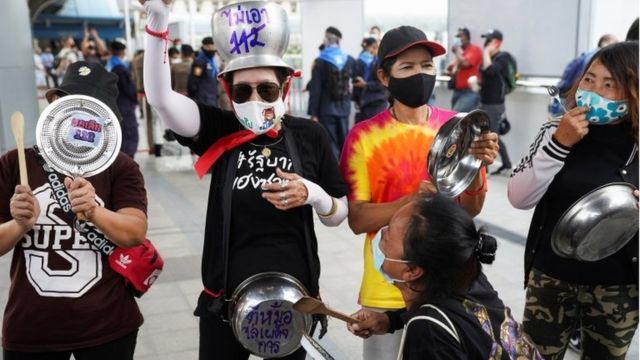 Pro-democracy protesters gather to bang pots and pans during a rally demanding the prime minister to resign and reforms on the monarchy, in Bangkok"s shopping district, Thailand, February 10, 2021