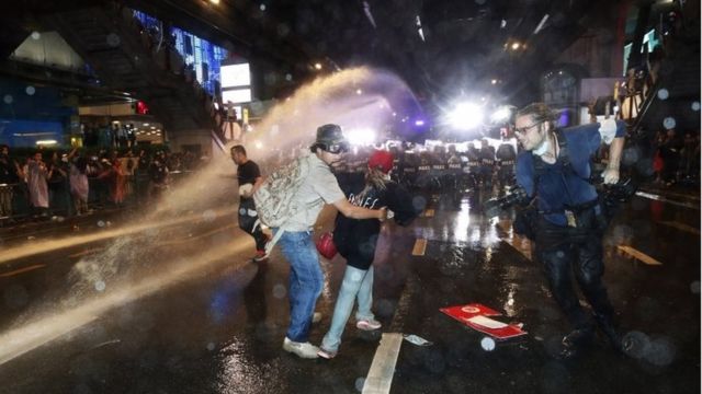 Riot police fire water canons at pro-democracy protesters and members of the media during an anti-government protest in Bangkok, Thailand, 16 October 2020.