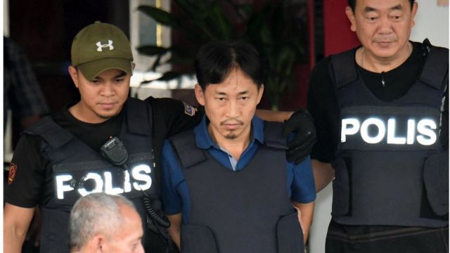 防弾チョッキを着用して警察署を出るリ・ジョンチョル氏(3日、マレーシア・セパン)