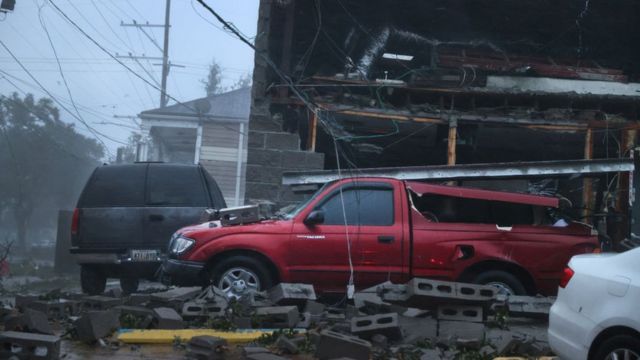 Edificio y vehículos dañados por el paso del huracán Ida.