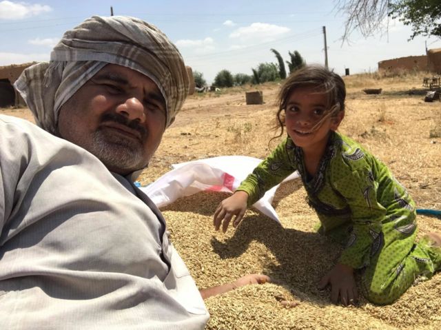 Abood Hamam and a girl with some harvested barley