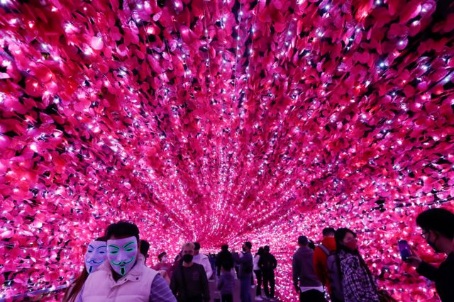 People take pictures on a footbridge with Christmas lights decorations in Taipei, Taiwan. Photo: 24 December 2021