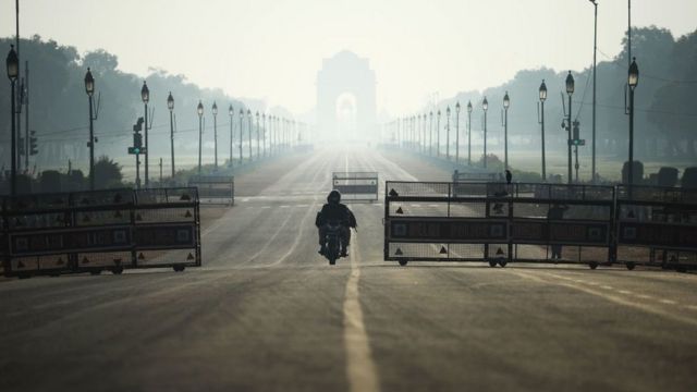 A motorist drives along the deserted Rajpath road during a one-day curfew in Janata (civil) imposed as a preventive measure against the COVID-19 coronavirus, in New Delhi on March 22, 2020.