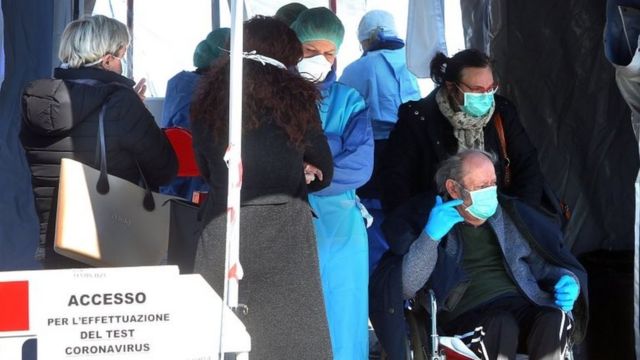 Italian healthcare staff of the infectious diseases department of the Padova Hospital wear protective suits and face masks as they swab people waiting in line in front of a Civil Protection tent due to the Covid 19 Coronavirus outbreak in Padua, Italy, 06 March 2020