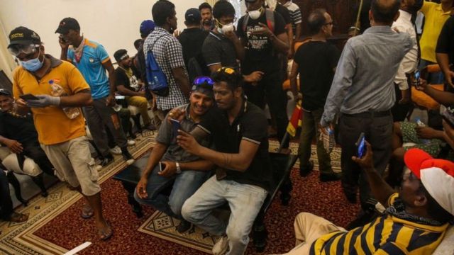 Citizens take pictures from inside the presidential palace halls