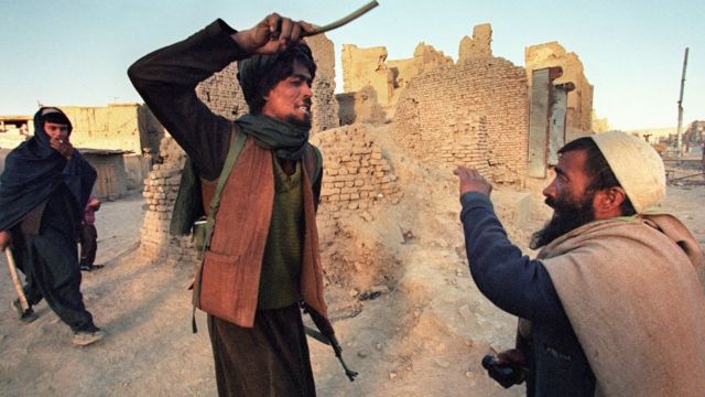 Un combatiente talibán castigando a otro hombre en Afganistán.
