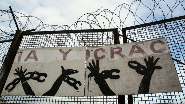 Pancartas de protesta con la palabra "democracia" a la entrada del centro de internamiento de inmigrantes en Aluche