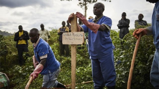 图为医护工作者在公墓参加埃博拉死亡率患者的葬礼