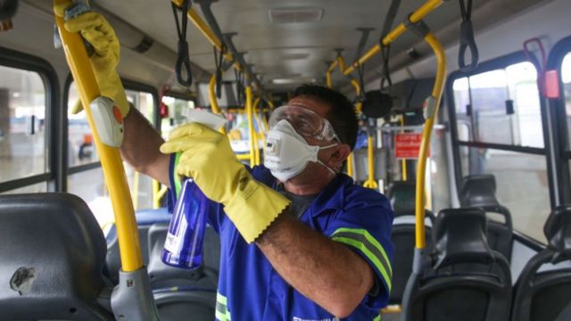 Un señor limpia las barandas de un autobús en Brasil