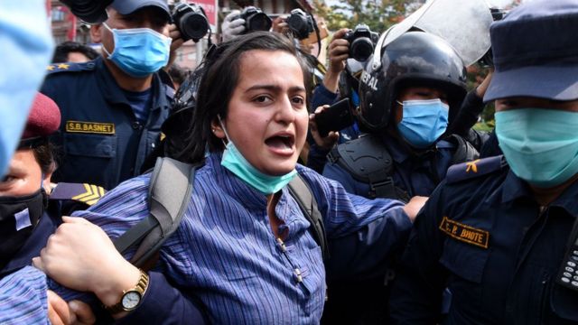 A demonstrator shouts slogans as she is detained by police during a protest against India"s newly inaugurated link road to the Chinese border, in Kathmandu on May 12, 2020.