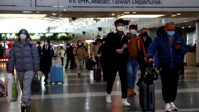 Viajantes caminhando pelo aeroporto internacional de Pequim na terça-feira, 27/12