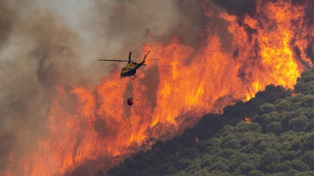 Helicóptero de combate a incêndios enfrenta parede de chamas nas colinas de Mijas, Espanha, 15 de julho de 22