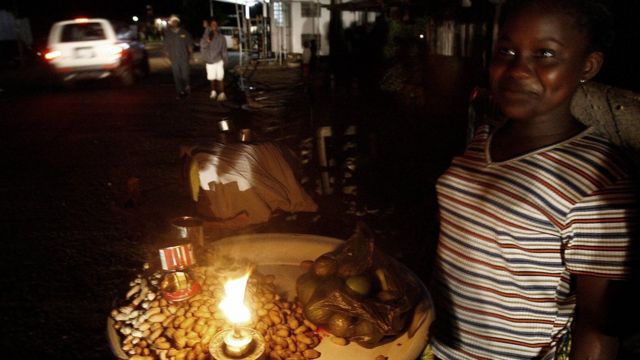 Un vendeur de rue sierra-léonais allume son étal avec une bougie à la fin du 04 juillet 2006 à Freetown