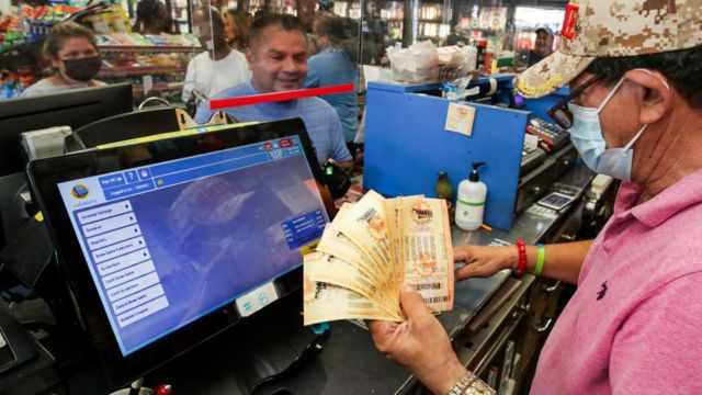 Imagem mostra homem comprando bilhetes de loteria