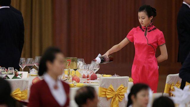 A hostess pours wine during a banquet in Beijing