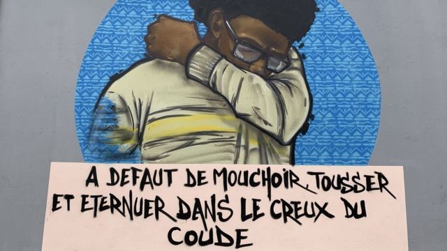 Mural en Dakar de un hombre tosiendo en su codo.