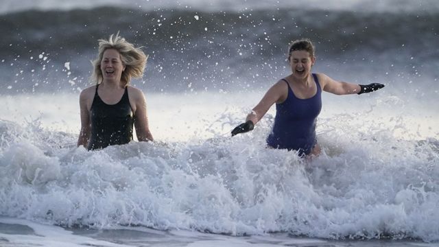 في خليج "كينغ إدوارد" بالقرب من بلدة تاين ماوث الساحلية في إنجلترا، السباحون يدخلون مياه بحر الشمال المتجمد في ليلة رأس السنة الجديدة.