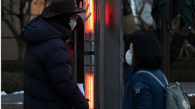 On the morning of the 27th, when the cold wave continues every day, a parking attendant warms his hands with a heater at Gwanghwamun intersection in Jongno-gu, Seoul.