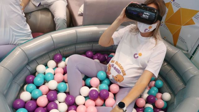 A pregnant woman with virtual reality glasses