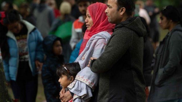 A Muslim family stands across the road from the Dean Street mosque