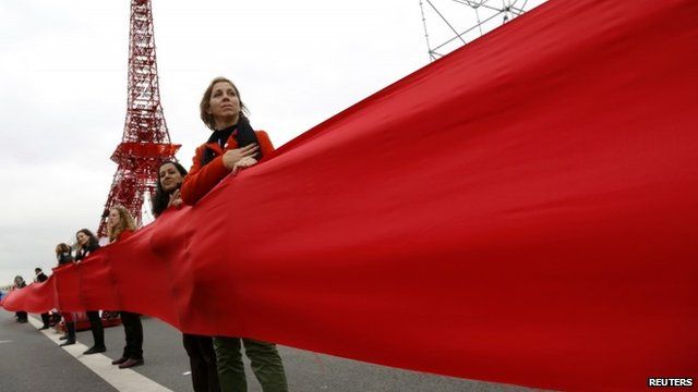 Women take part in a giant red line demonstration as an act of climate disobedience from the COP21 Eiffel Tower replica down the Champs Elysee corridor