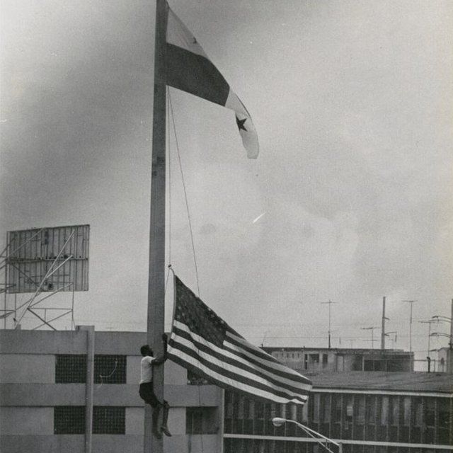 Un joven sustituye la bandera estadounidense por la panameña.