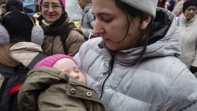 سيدة وطفلها أثناء إجلاء من مدينة كييف