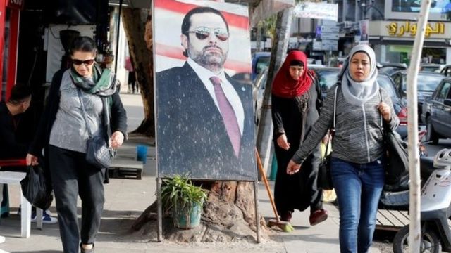 Mujeres pasan al lado de una foto de Saad Hariri en Beirut.