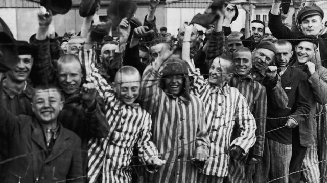 В'язні концтабору Дахау вітають американських солдатів, які прийшли їх звільнити