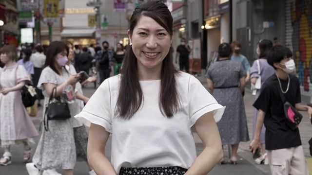 A ativista de saúde sexual Asuka Someya parada em frente a uma rua movimentada