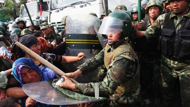 Policías chinos empujan a mujeres uigures que protestan en Urumqi, la capital de la región autónoma uigur de Xinjiang, China, el 7 de julio de 2009.