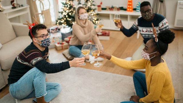 Pessoas de máscara brindando o Natal