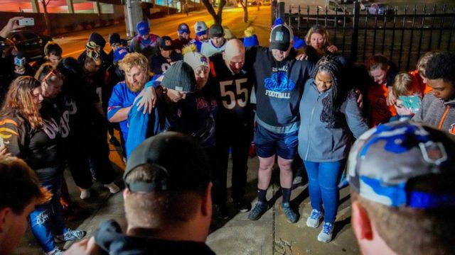 Fanáticos del fútbol rezan afuera del Centro Médico de la Universidad de Cincinnati después de que Damar Hamlin colapsara en el campo de juego el lunes.
