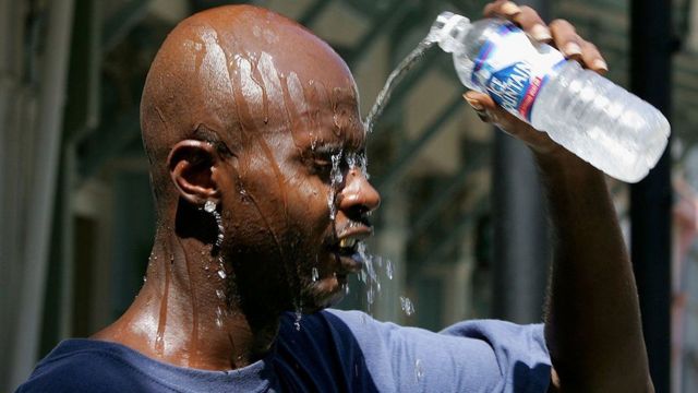 Hombre en Nueva Orleans mojando su rostro durante una ola de calor
