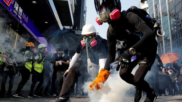 Anti-government protesters in Hong Kong holding a tear gas canister on 20 October 2019