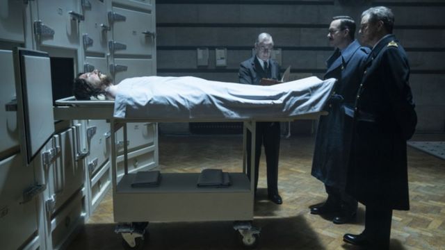 Cena do filme Operation Mincemeat. Agentes britânicos são vistos em frente aos restos mortais de Michael