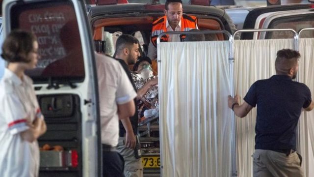 امدادگران، زن اسرائیلی را پس از حمله با چاقو به بیمارستان می‌برند