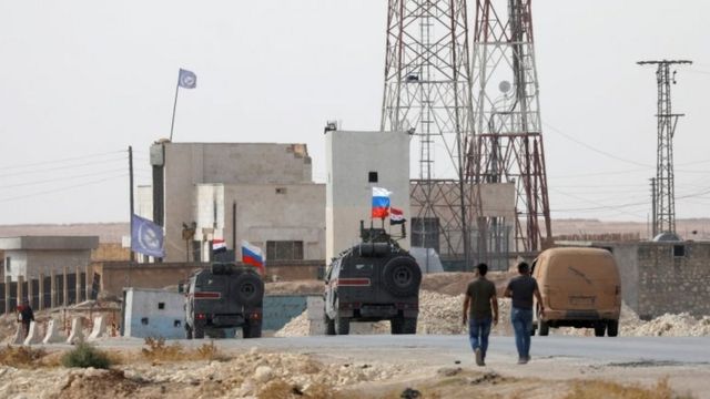Menbic yakınlarında Suriye ve Rusya bayraklarıyla devriye gezen askeri araçlar