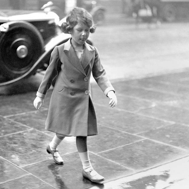 Princess Elizabeth walking through the rain on her arrival home