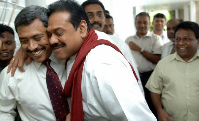 Colombo, SRI LANKA: Sri Lankan Defence Ministry Secretary Gotabaya Rajapakse (L) is hugged by elder brother Sri Lankan President Mahinda Rajapakse (C) in Colombo, 01 December 2006, after narrowly escaping assassination in a suicide bomb attack in the Sri Lankan capital. A suspected Tamil suicide bomber attacked a defence ministry convoy carrying the president's brother, killing at least one soldier, police said. Gotabaye Rajapakse, secretary to the defence ministry and brother of President Mahinda Rajapakse, was unhurt after the blast in the heart of the Sri Lankan capital.