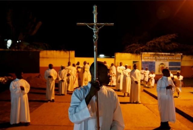 An altar boys holds a cross before a mass at the Notre Dame de Kinshasa cathedral in Kinshasa, the Democratic Republic of Congo