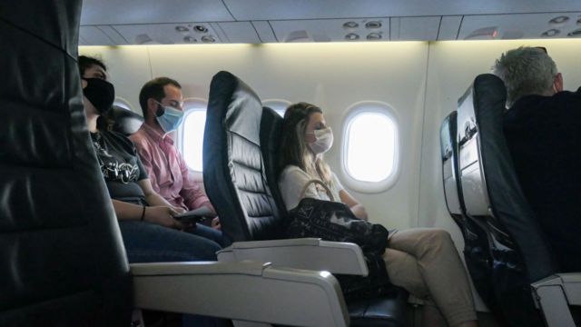 Passengers with masks on an airplane
